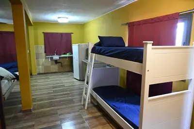 a room with two bunk beds and a bathroom at Lucerito no reserve x aca in Villa Santa Cruz del Lago