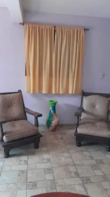a living room with two chairs and a window at Complejo de cabañas el Winon in Cuesta Blanca