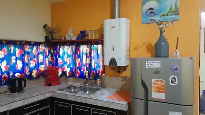 a kitchen with a sink and a refrigerator at Complejo de cabañas el Winon in Cuesta Blanca