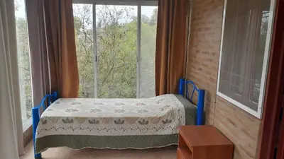 a bedroom with a bed in front of a window at Complejo de cabañas el Winon in Cuesta Blanca