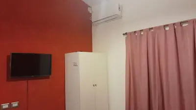 a television on a wall next to a curtain at Complejo de cabañas el Winon in Cuesta Blanca