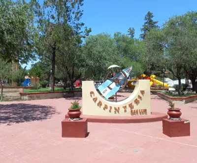 a sign in a park with a roller coaster at Cabañas Lumel in Carpintería
