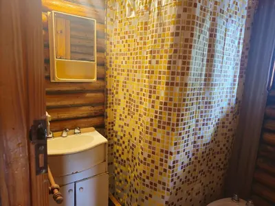 a bathroom with a sink and a yellow tiled shower curtain at Cabañas Lumel in Carpintería
