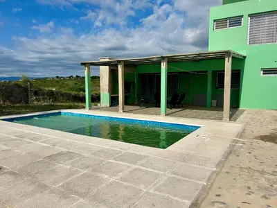 a house with a swimming pool in front of it at Casita verde in Villa Santa Cruz del Lago