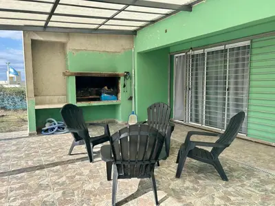 a patio with chairs and a table and a green wall at Casita verde in Villa Santa Cruz del Lago