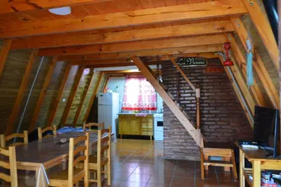 a kitchen and dining room with a table and a staircase at Cerro del Alma in Villa Yacanto