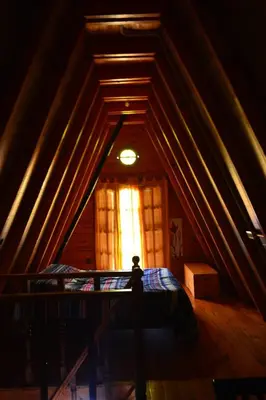 a attic room with a bed and a window at Cerro del Alma in Villa Yacanto