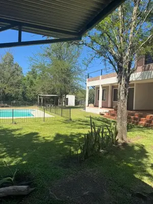 a house with a pool and a tree in the yard at El Rincon Verde in Bialet Massé