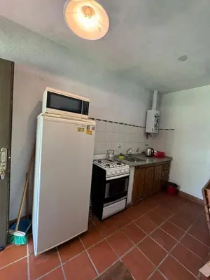 a small kitchen with a refrigerator and a stove at El Rincon Verde in Bialet Massé