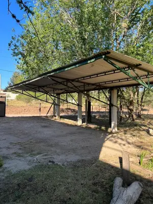 a pavilion with a roof on top of a field at El Rincon Verde in Bialet Massé