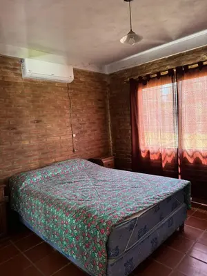 a bedroom with a bed in a room with two windows at El Rincon Verde in Bialet Massé