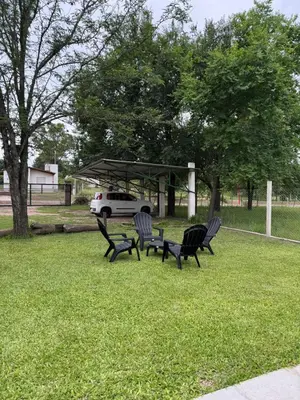 a group of chairs sitting in a park with a car at El Rincon Verde in Bialet Massé