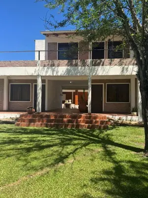 a house with a tree in front of a yard at El Rincon Verde in Bialet Massé