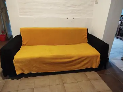 a couch with a yellow blanket on top of it at DepartamentoVCP in Villa Carlos Paz