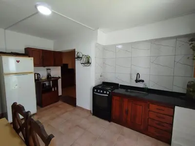a kitchen with a black stove and a refrigerator at DepartamentoVCP in Villa Carlos Paz