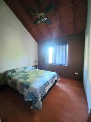 a bedroom with a bed and a ceiling fan at Tantanakuy 3 in Villa General Belgrano