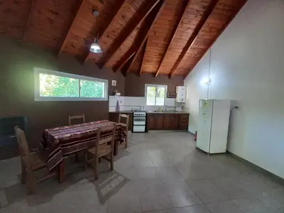 a kitchen and dining room with a table and a refrigerator at Tantanakuy 3 in Villa General Belgrano