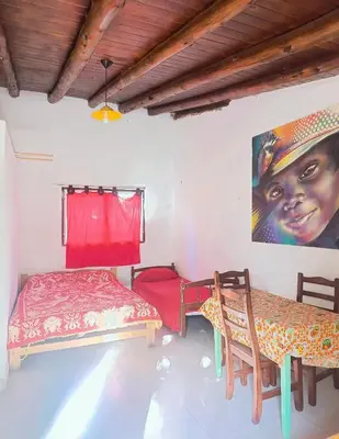 a room with two beds and a painting on the wall at Cabañas TUPAC LIHUE in Arroyo de Los Patos