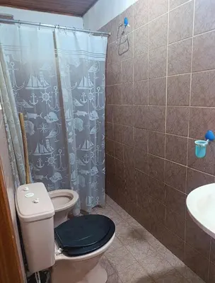 a bathroom with a toilet with a shower curtain at Cabañas TUPAC LIHUE in Arroyo de Los Patos