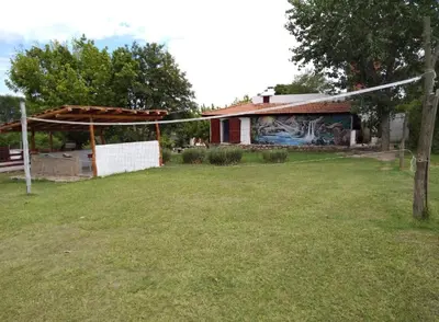 a house with a yard with a net in front of it at Cabañas TUPAC LIHUE in Arroyo de Los Patos
