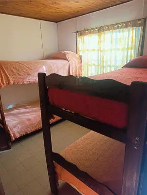 a room with two bunk beds and a window at Cabañas TUPAC LIHUE in Arroyo de Los Patos