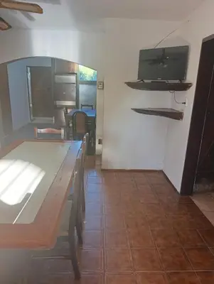 a dining room with a table and a tv on a wall at Cabañas TUPAC LIHUE in Arroyo de Los Patos