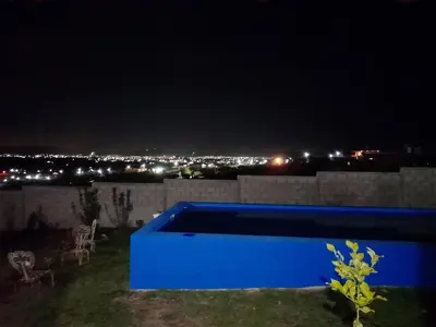 a blue pool on top of a house at night at Brisas de las Sierras in Tanti