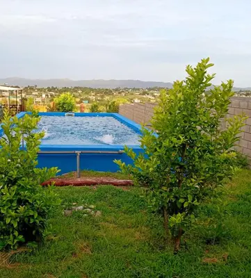 a swimming pool in a yard with two trees at Brisas de las Sierras in Tanti