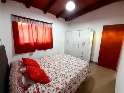 a bedroom with a bed with red pillows on it at Brisas de las Sierras in Tanti