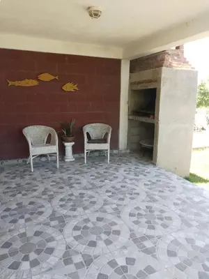 a patio with two chairs and a brick wall at Lucrecia in Villa Parque Siquiman