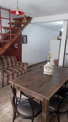 a living room with a wooden table and a couch at Lucrecia in Villa Parque Siquiman
