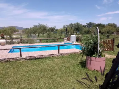 a swimming pool in a yard with a field at Lucrecia in Villa Parque Siquiman