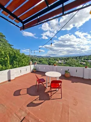 a patio with two chairs and a table on a roof at Cielo Serrano VCP in Villa Carlos Paz