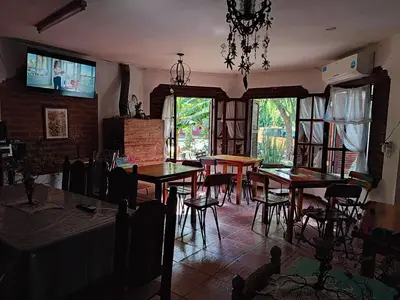 a dining room with tables and chairs and windows at maemm el castillto in Mina Clavero