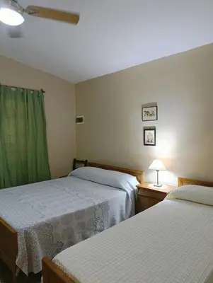 a bedroom with two beds and a green curtain at Casa en centro de Icho Cruz in Villa Icho Cruz