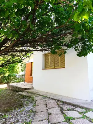 a white building with a window with a yellow shutter at Casa en centro de Icho Cruz in Villa Icho Cruz