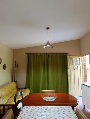 a dining room with a table and a green curtain at Casa en centro de Icho Cruz in Villa Icho Cruz