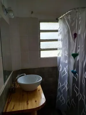a bathroom with a bowl on a wooden table with a shower curtain at Fermina in Villa Icho Cruz