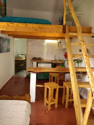 a room with a loft bed and a table and stool at Fermina in Villa Icho Cruz