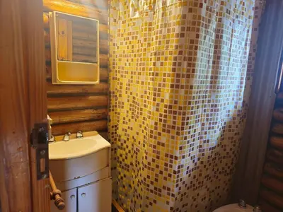 a bathroom with a sink and a yellow tiled shower curtain at Cabañas Lumel in Carpintería