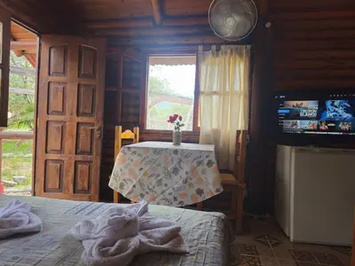 a bedroom with a table and a bed and a window at Cabañas Lumel in Carpintería