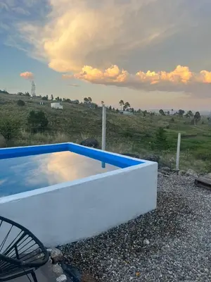 a white and blue swimming pool in a field at ecolodge in San Pedro