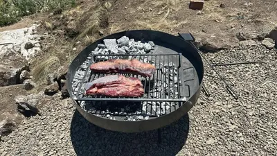 two pieces of meat cooking on a grill at ecolodge in San Pedro