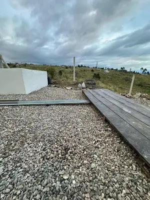 a wooden bridge on a field with rocks and a sky at ecolodge in San Pedro
