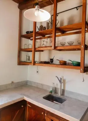 a kitchen counter with a sink and wooden cabinets at Cabaña para 2 Personas en Arroyo de los patos in Arroyo de Los Patos