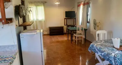 a room with a refrigerator and a table with a table at Cabaña para 2 Personas en Arroyo de los patos in Arroyo de Los Patos