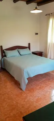 a bedroom with a large bed with blue sheets at Cabaña para 2 Personas en Arroyo de los patos in Arroyo de Los Patos