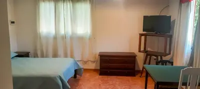 a bedroom with a bed and a tv and a table at Cabaña para 2 Personas en Arroyo de los patos in Arroyo de Los Patos