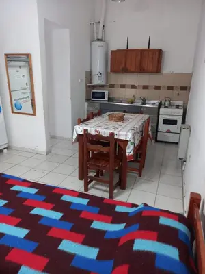 a kitchen with a table and a kitchen with a stove at Departamento 1 Doña Victoria in Villa Carlos Paz