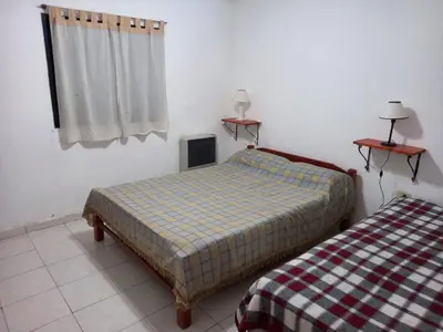 a bedroom with two beds and a window at Departamento 1 Doña Victoria in Villa Carlos Paz